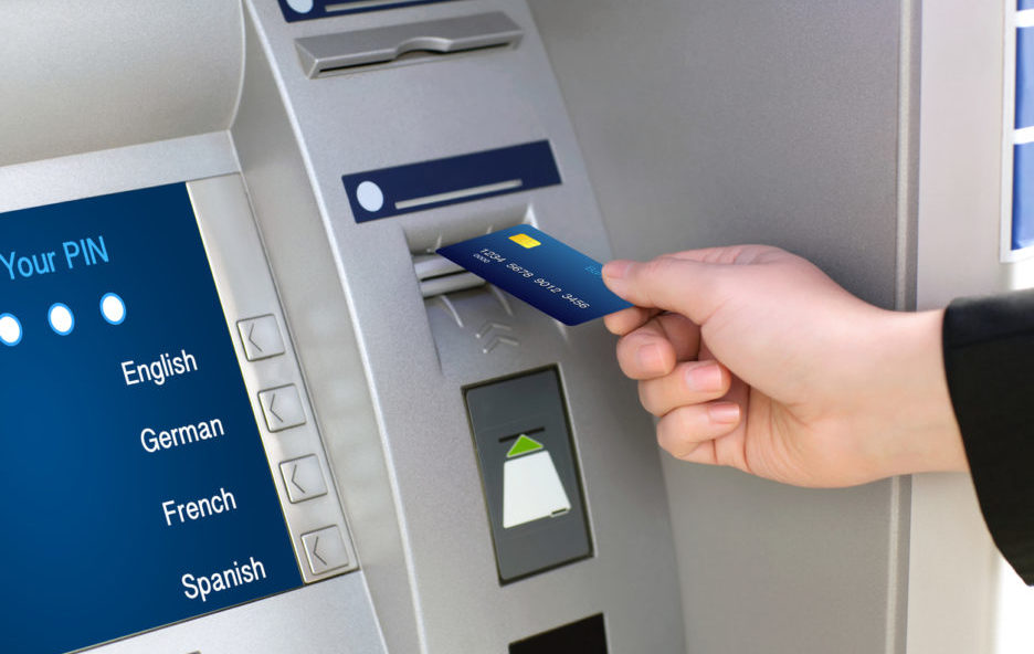 men hand businessman puts credit card into ATM
