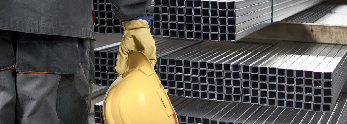 worker with helmet in front of steel sheet metal profiles